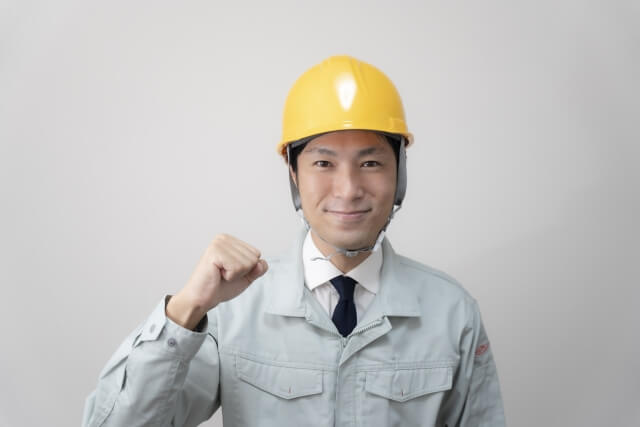 拳を握る作業服の男性